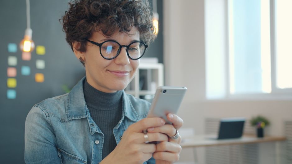 スマホを見て笑顔になる女性